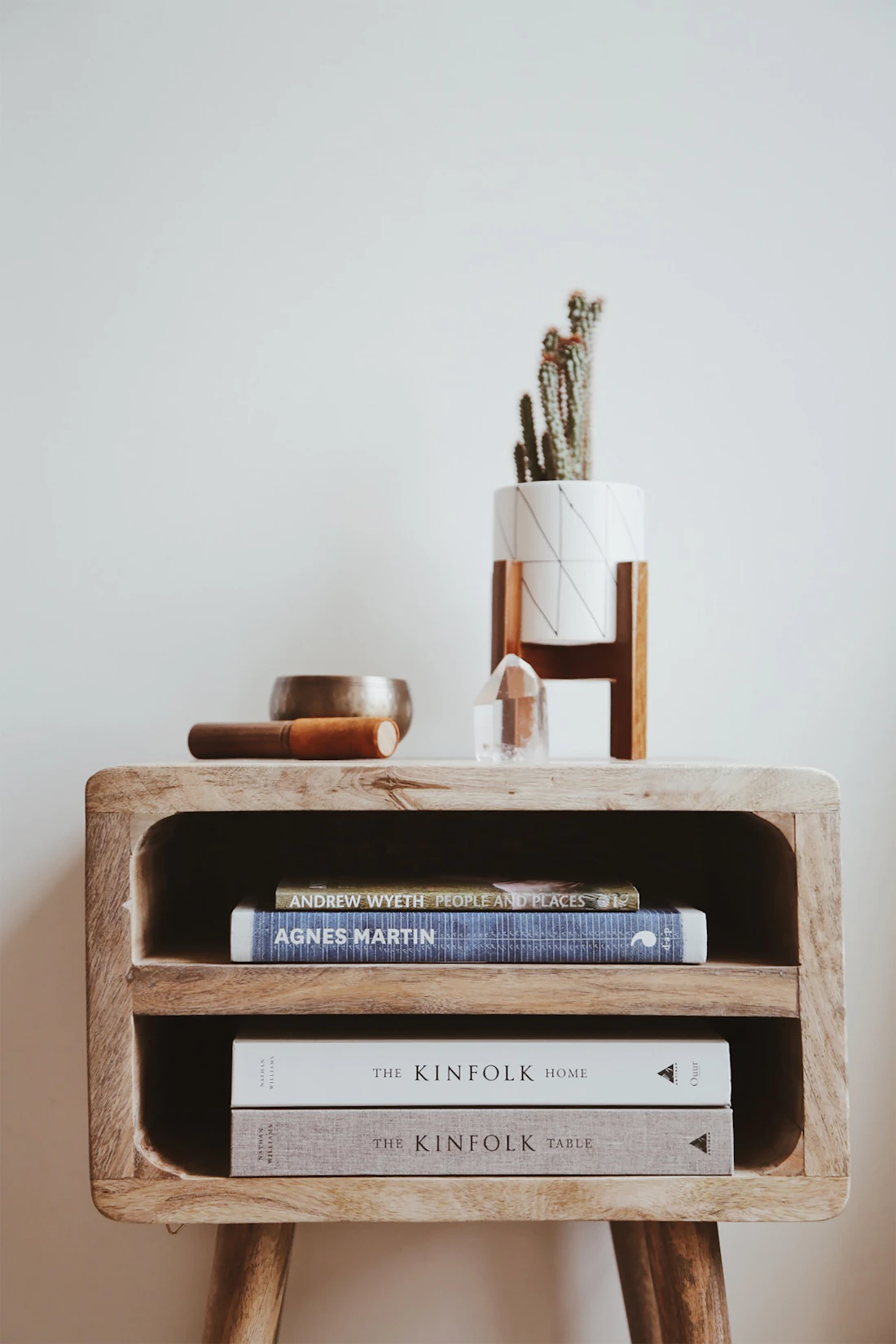 Mueble auxiliar de madera con libros y objetos decorativos